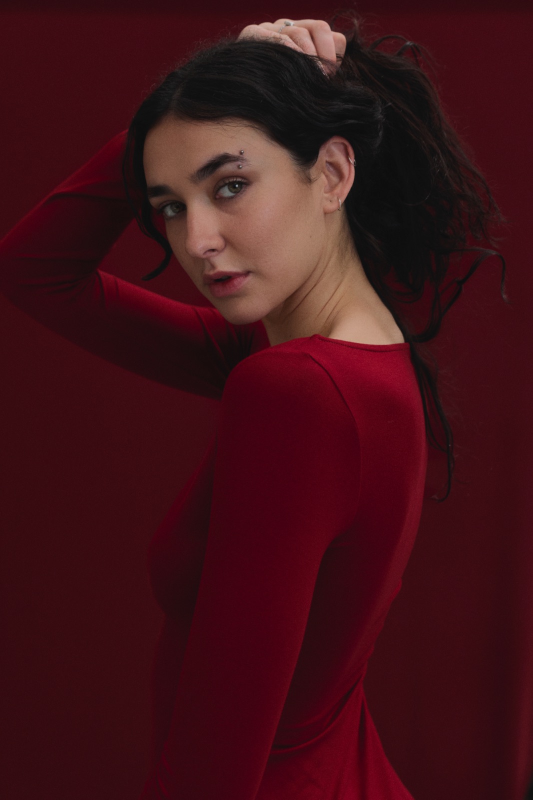 Katja in red looking back over her shoulder against red fabric, photographed by Eli Samuel for Australian Stitch.