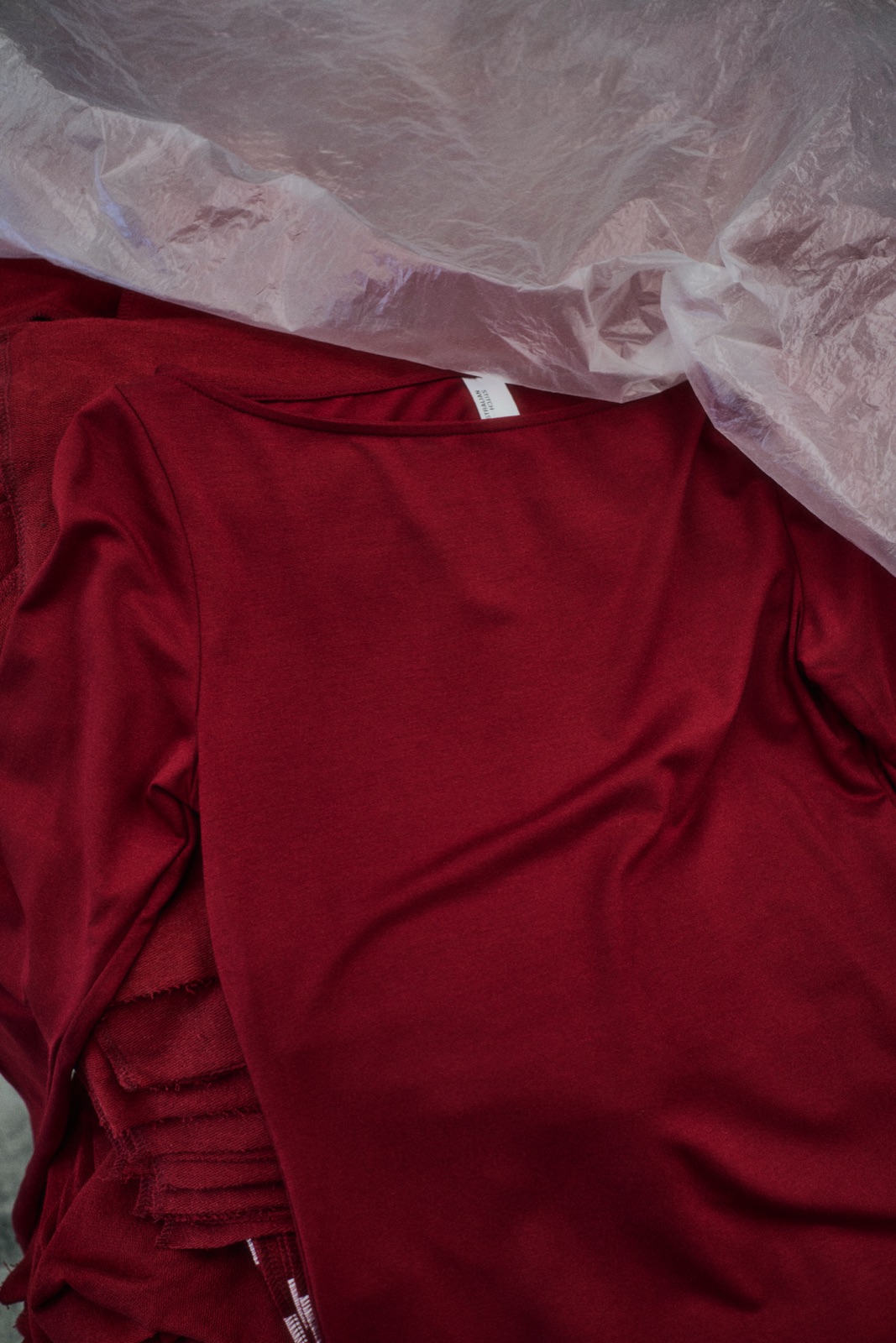 Close detail of a red garment in plastic wrap, photographed by Eli Samuel for Australian Stitch.