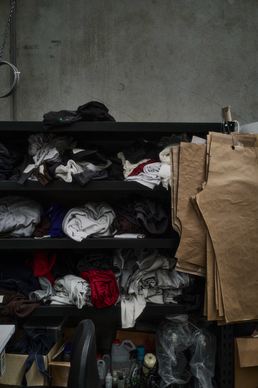 Shelves of folded fabric and brown paper patterns in the factory, photographed by Eli Samuel for Australian Stitch.