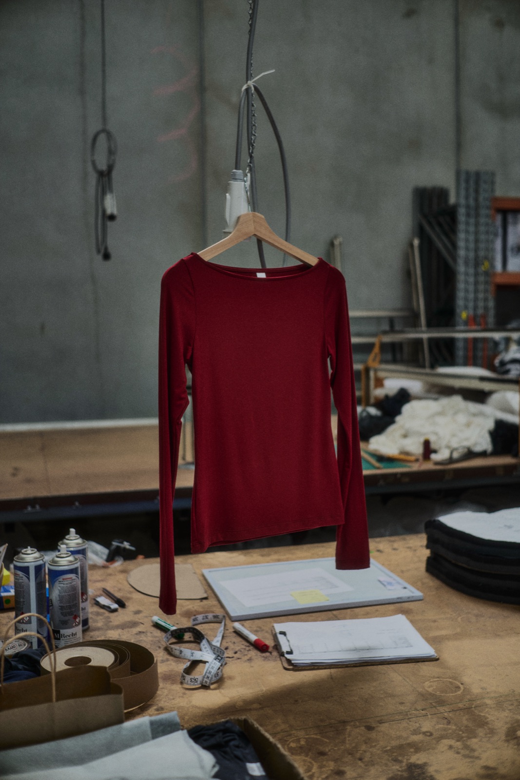 A red long sleeve top on a hanger above a cutting table, photographed by Eli Samuel for Australian Stitch.