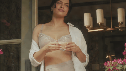 Woman in lace lingerie and an open robe holding a cup