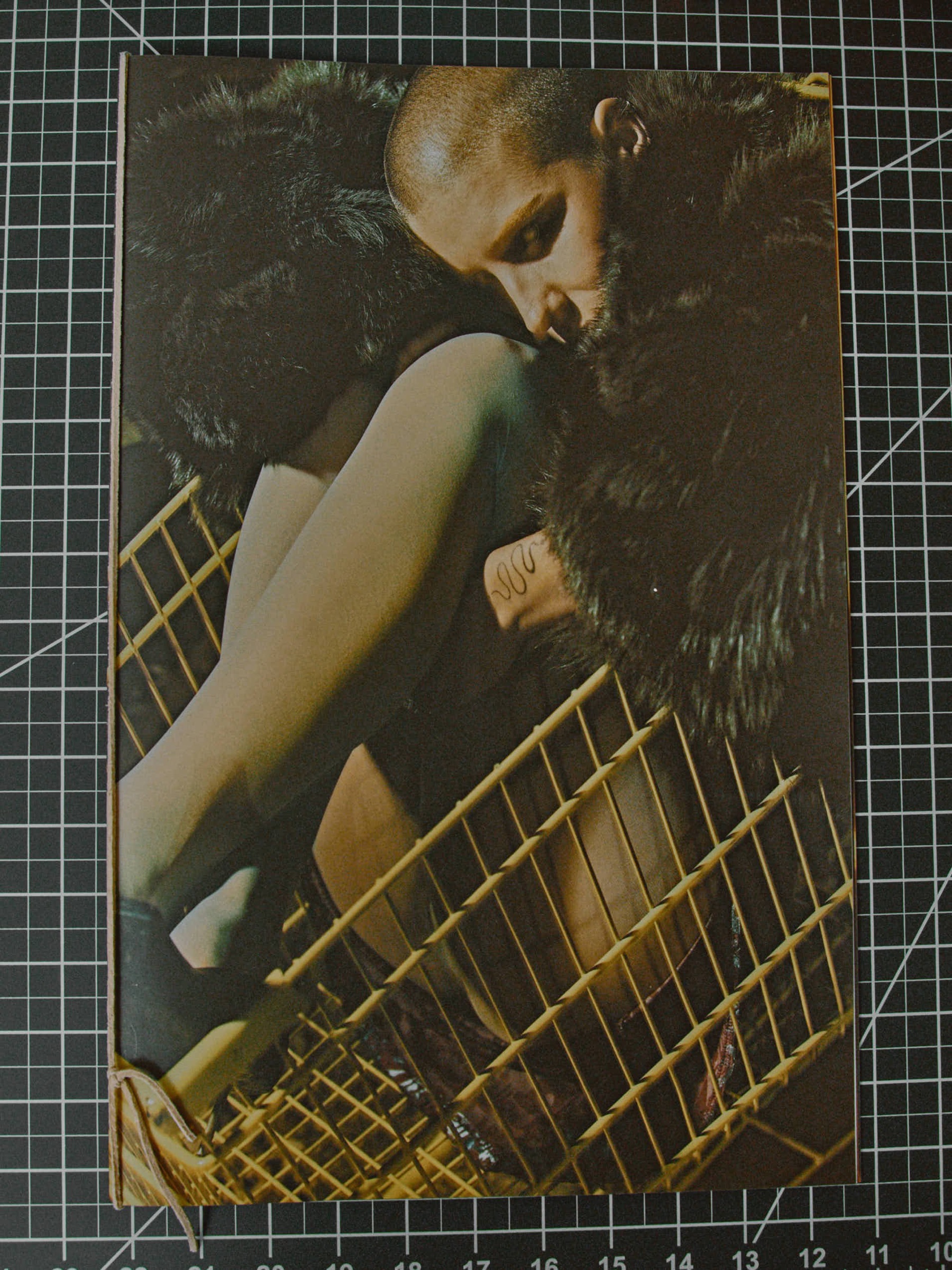 Close-up, fur-wrapped figure in a wire chair