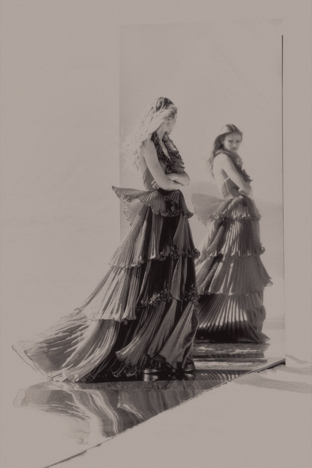 Model Scarlett Leithold in a pleated gown for Sherri Hill, reflected in wet sand at El Castillo de Arena Beach, Baja California Sur, Mexico, May 2, 2024, photographed by Eli Samuel. Make-up by Jessica Chan, produced by Cody Hill.